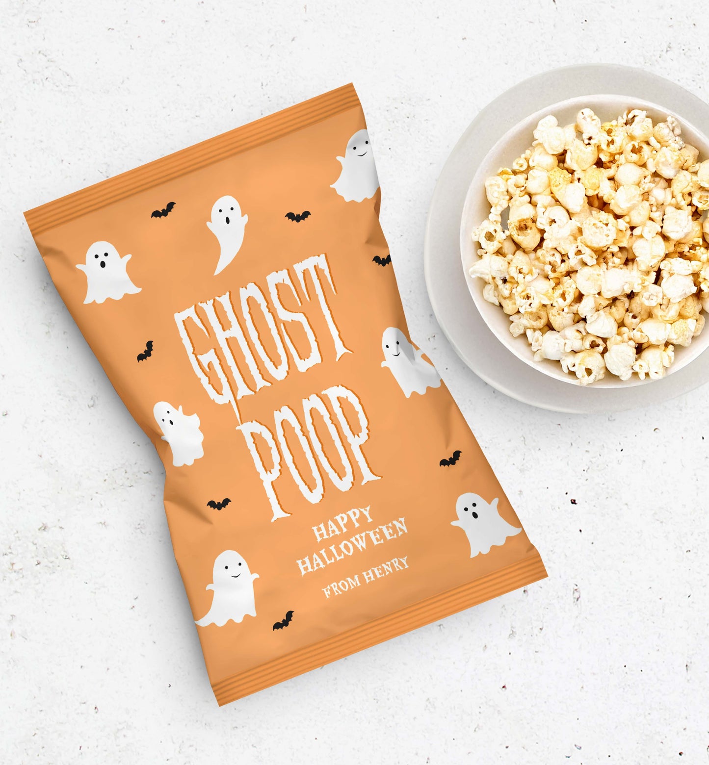 Halloween-themed popcorn bag with ghost design and a bowl of popcorn on a white surface. Ghost Poop Popcorn Bag Wrapper, Printable Halloween Trick Or Treat Gift, Classroom Halloween Gift, Halloween Popcorn Bag Wrapper