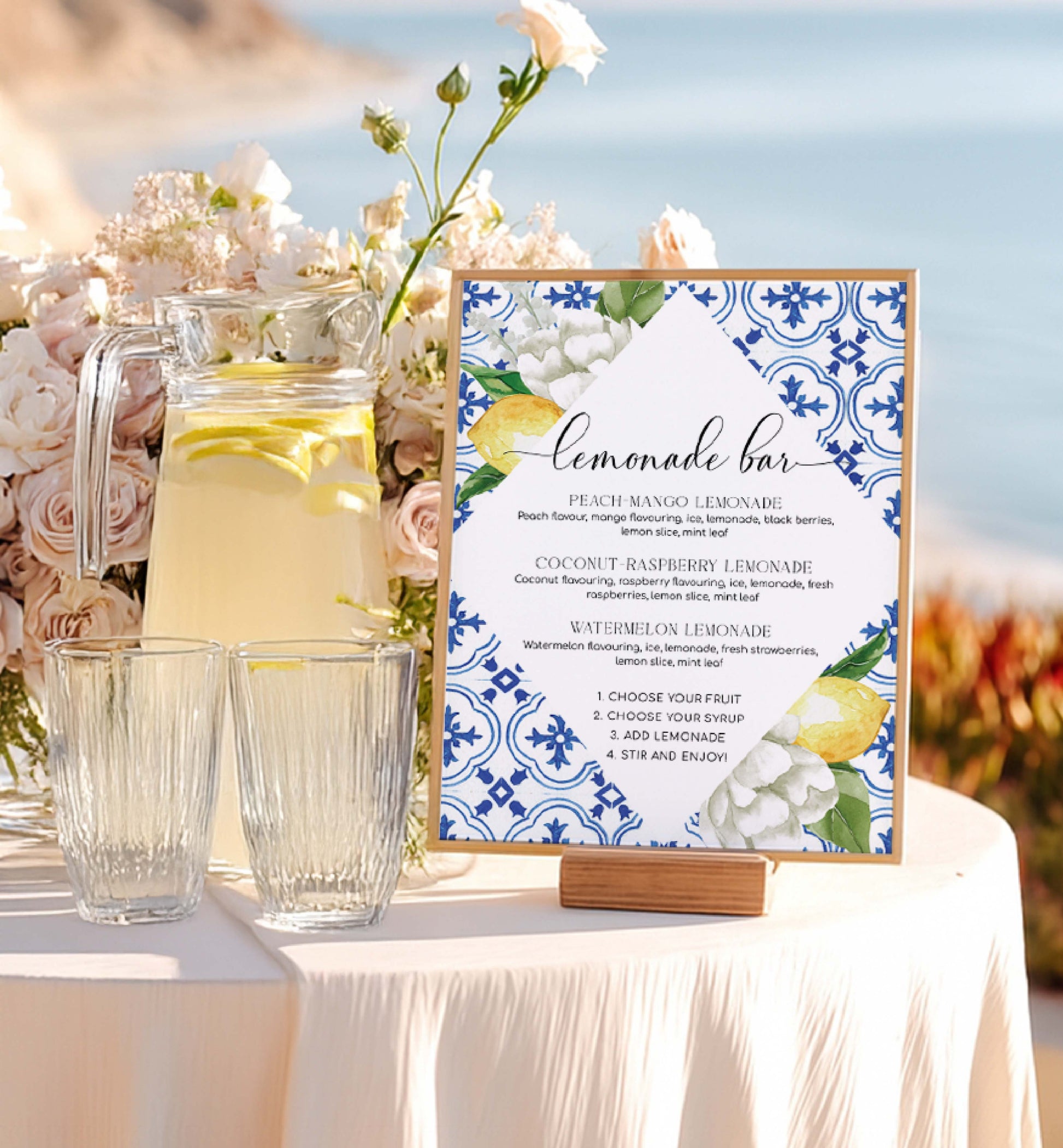 Lemonade bar setup with pitcher, glasses, and decorative sign outdoors. Lemonade Bar Sign, Mediterranean Blue Tile Lemons, Printable Bridal Shower Bar Sign, Wedding Bar Sign, Italian Theme, Capri, Mocktail Bar Menu, The Med