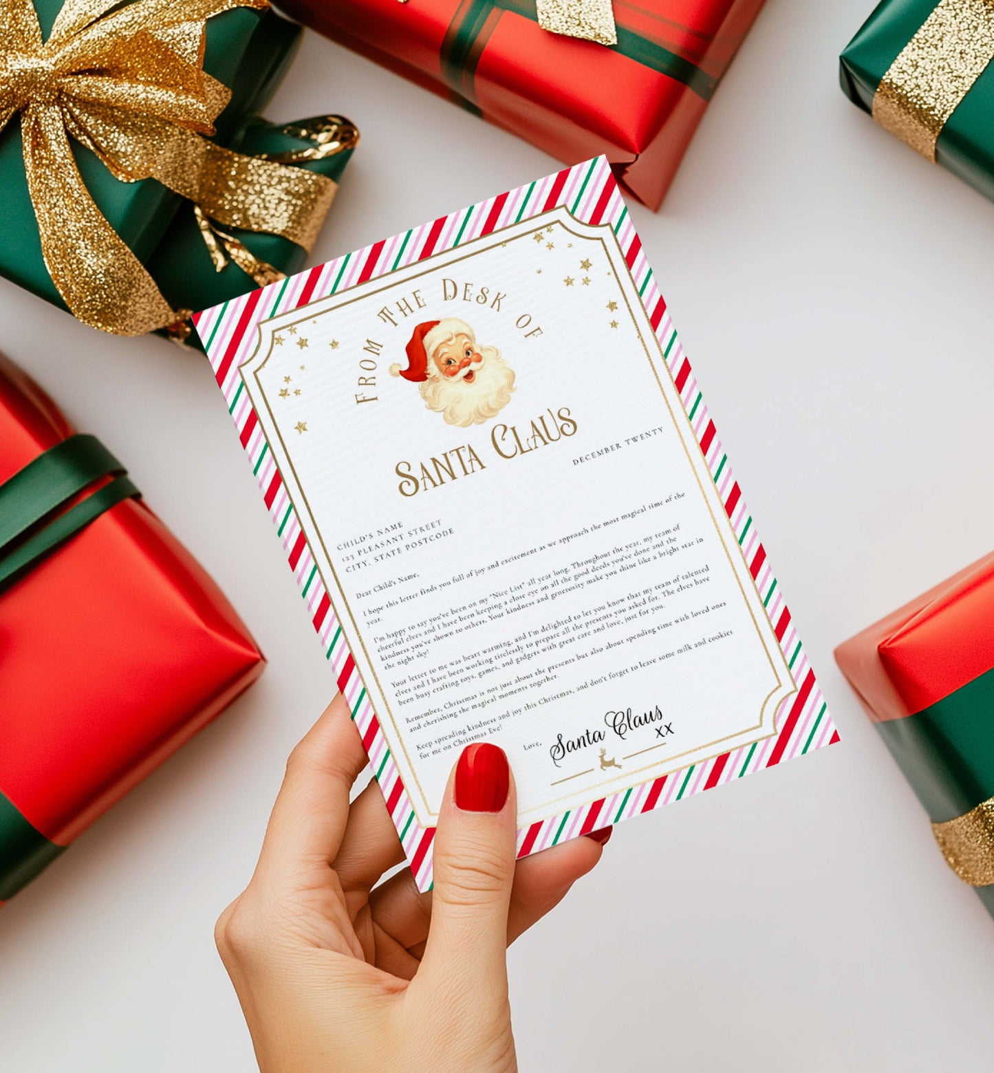 Letter from Santa Claus held by a hand with red nail polish, surrounded by Christmas presents. Printable Letter From Santa Template, Approved Nice List Member Letter From Santa Claus, Christmas Letter From Santa, Stripe