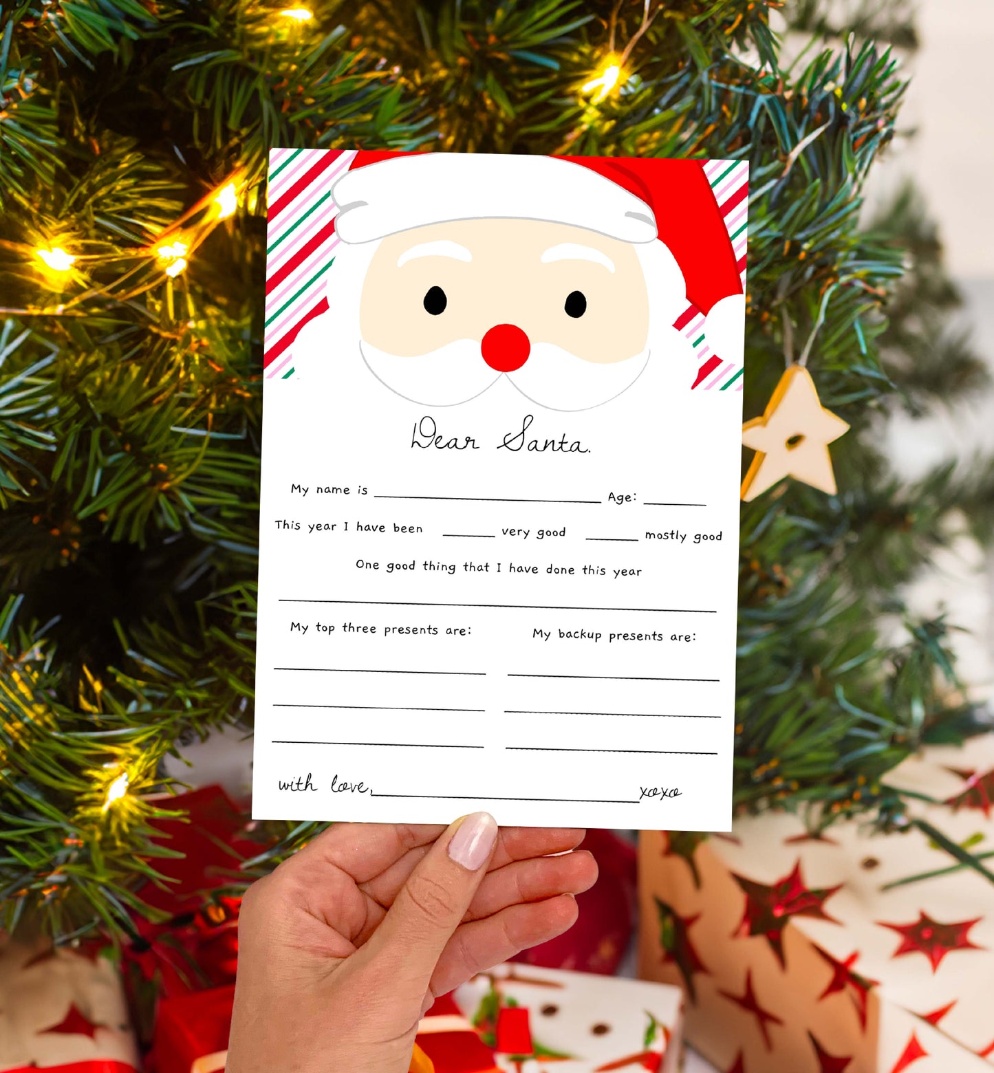 Santa Claus letter template held in front of a Christmas tree with lights and presents. Printable Letter To Santa Template, Christmas Eve Mail for Kids, Children's Christmas Wish List, Dear Santa Christmas Letter, Stripe Pink