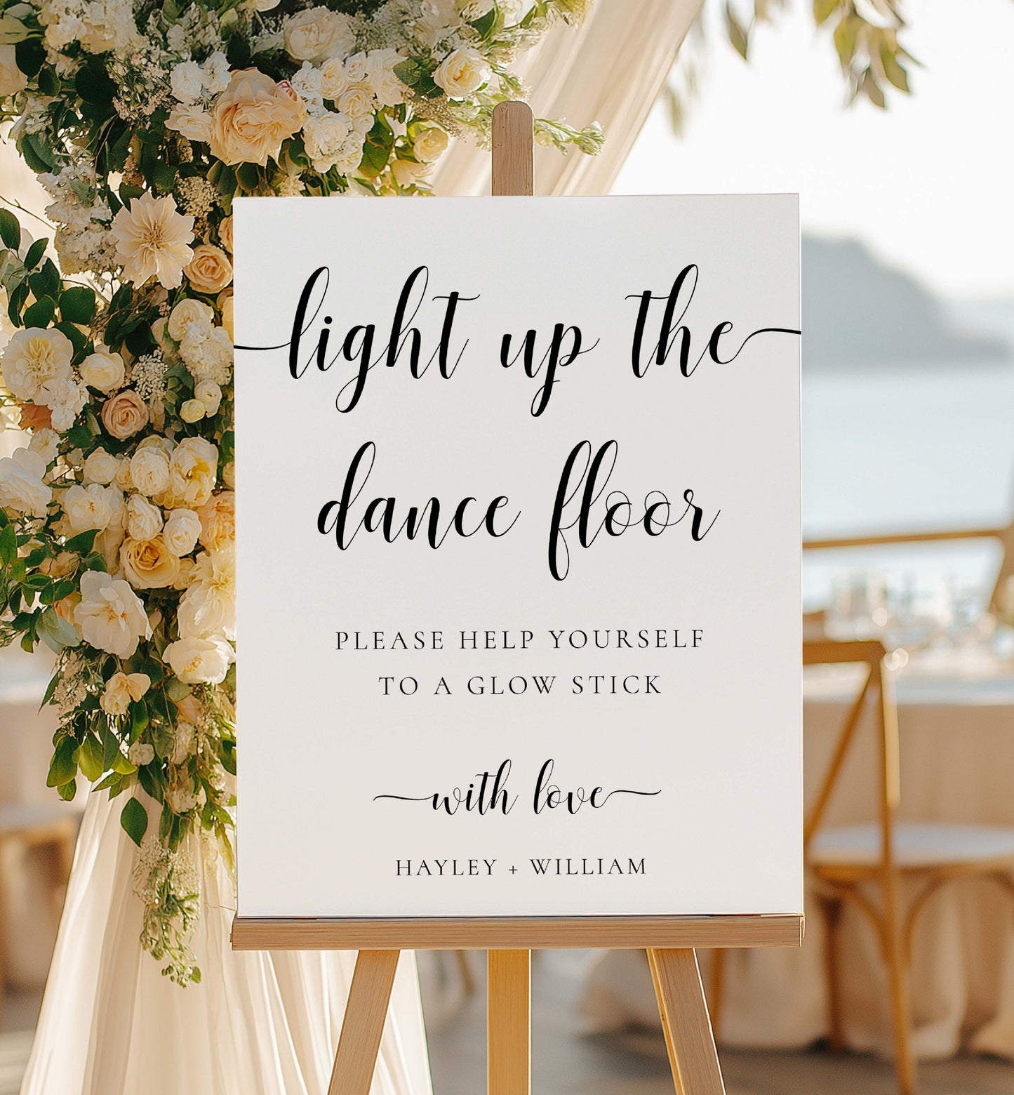 Decorative sign with floral arrangement on a stand at a wedding reception. Printable Wedding Glow Stick Sign, Minimalist Wedding Light Up The Dance Floor Sign, Editable Let Love Glow Sign Template, Leyton