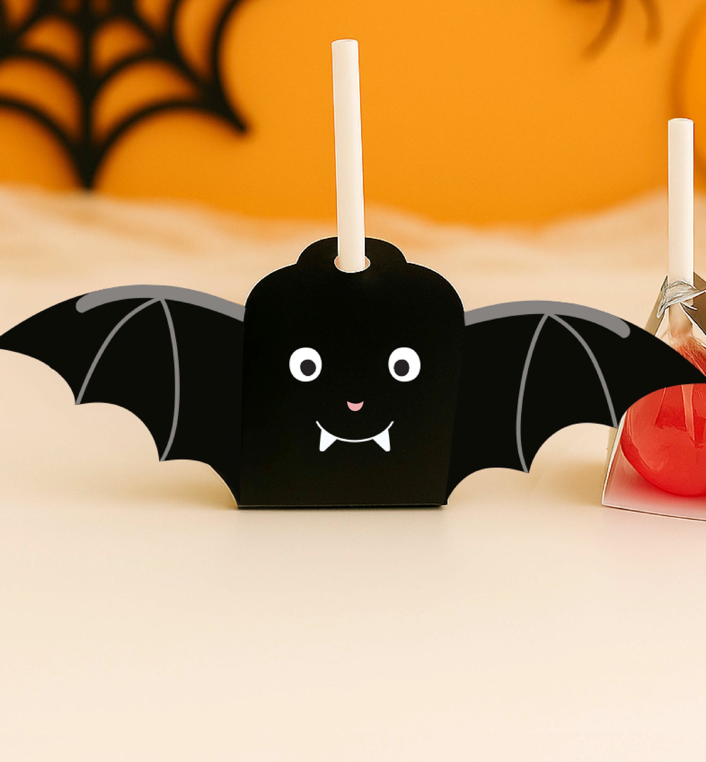 Halloween-themed bat-shaped candy holder with a red ball inside on a light background. Printable Halloween Lollipop Tags Template, Halloween Trick or Treat Sucker Tag, Kids Classroom Halloween, Friends Halloween Gift