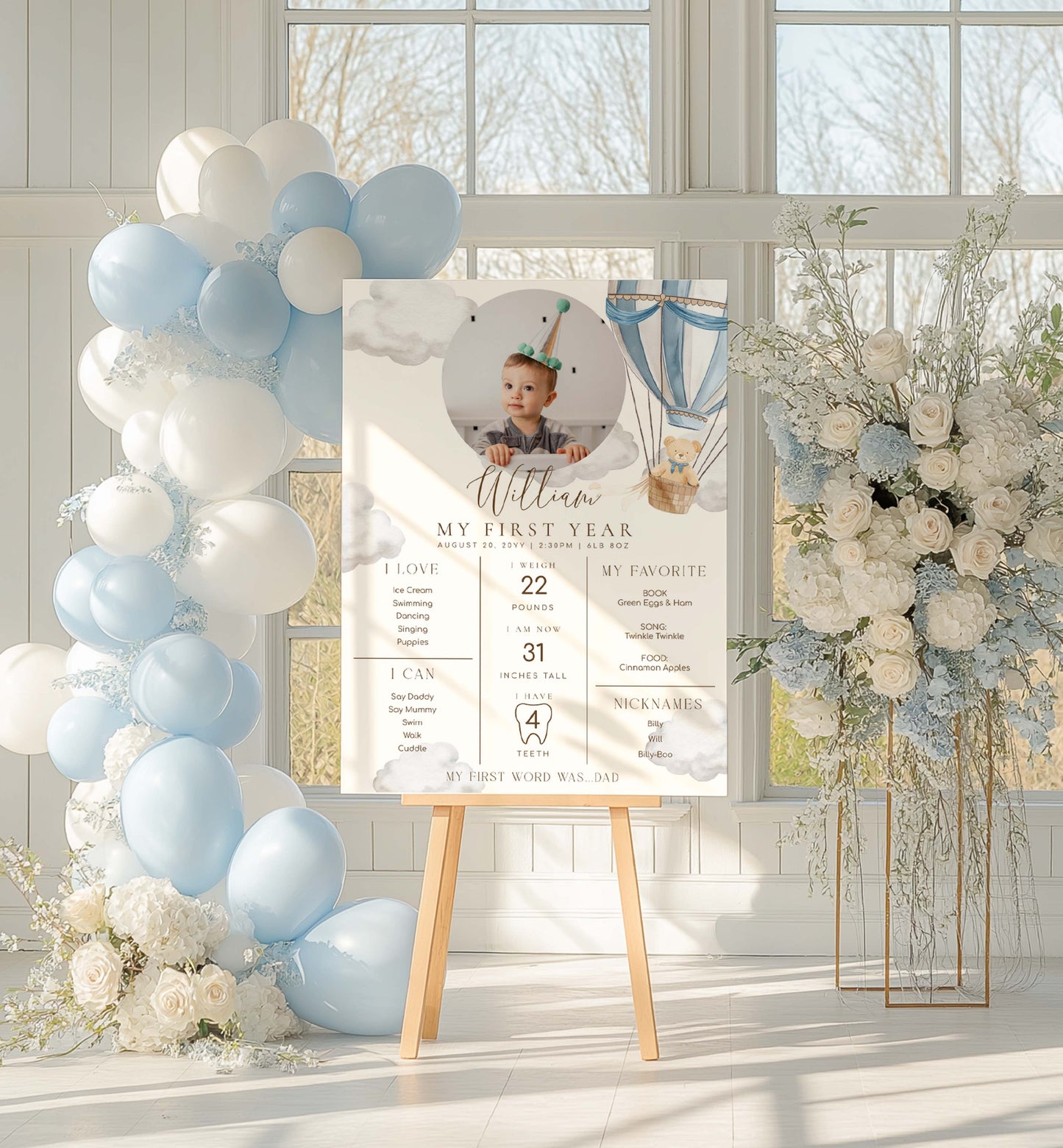 Decorative setup with balloons, flowers, and a photo of a child on an easel in a bright room. Printable Baby Milestone Board, Teddy Bear Beary First Birthday, Baby's First Year Poster, 1st Birthday 12 Months Milestone Photo Banner Sign
