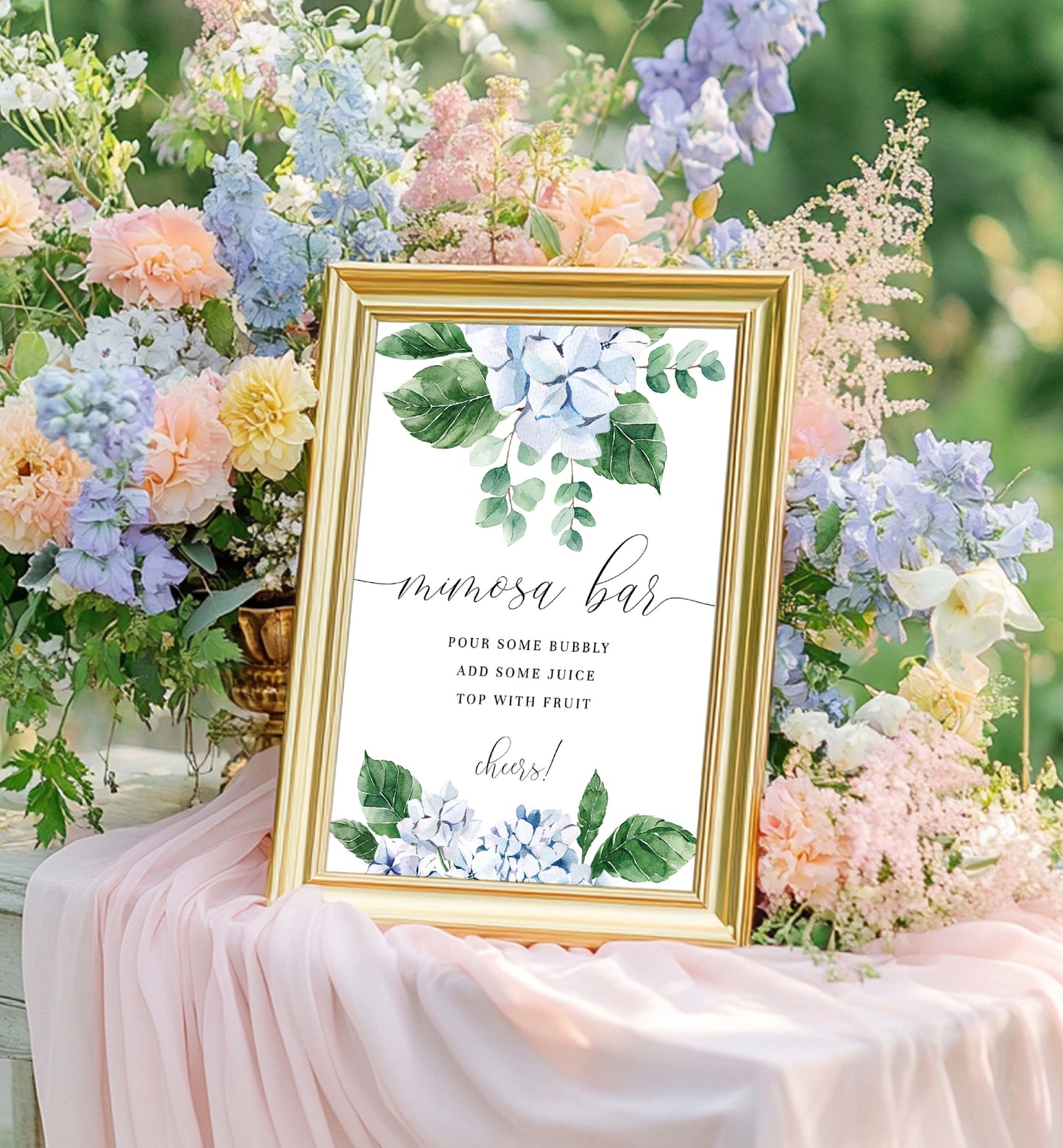 Decorative sign for a mimosa bar surrounded by flowers and fabric. Printable Mimosa Bar Sign and Juice Tags Template, Blue Hydrangea Boy Baby Shower Drinks Bar Menu Sign, Gender Neutral, Ferras Blossom