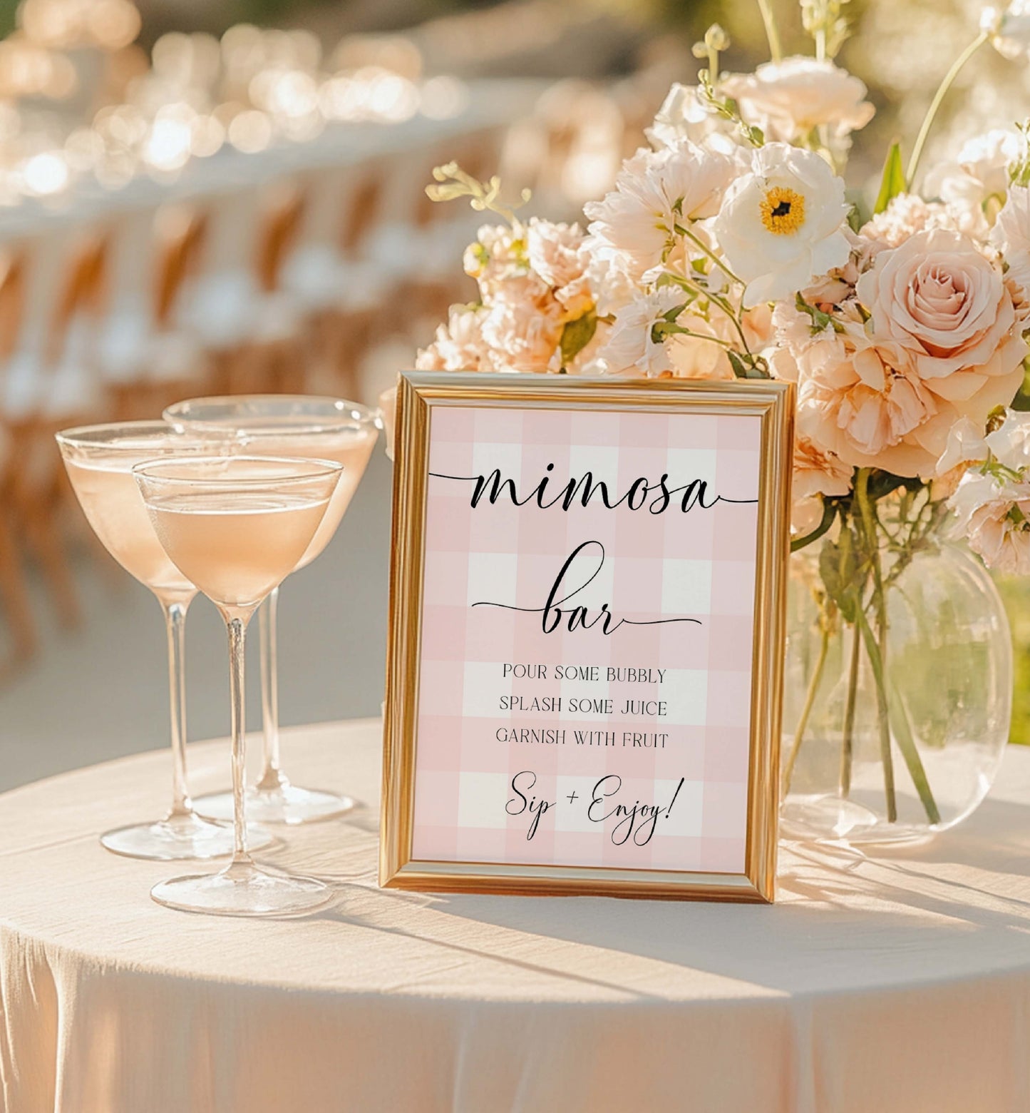 Mimosa bar setup with glasses of pink champagne and a sign on a table. Printable Mimosa Bar Sign and Juice Tags, Pink Gingham Check, Girl Baby Shower Mom-osa Bar Sign, Baby Shower Mocktails Drinks Sign