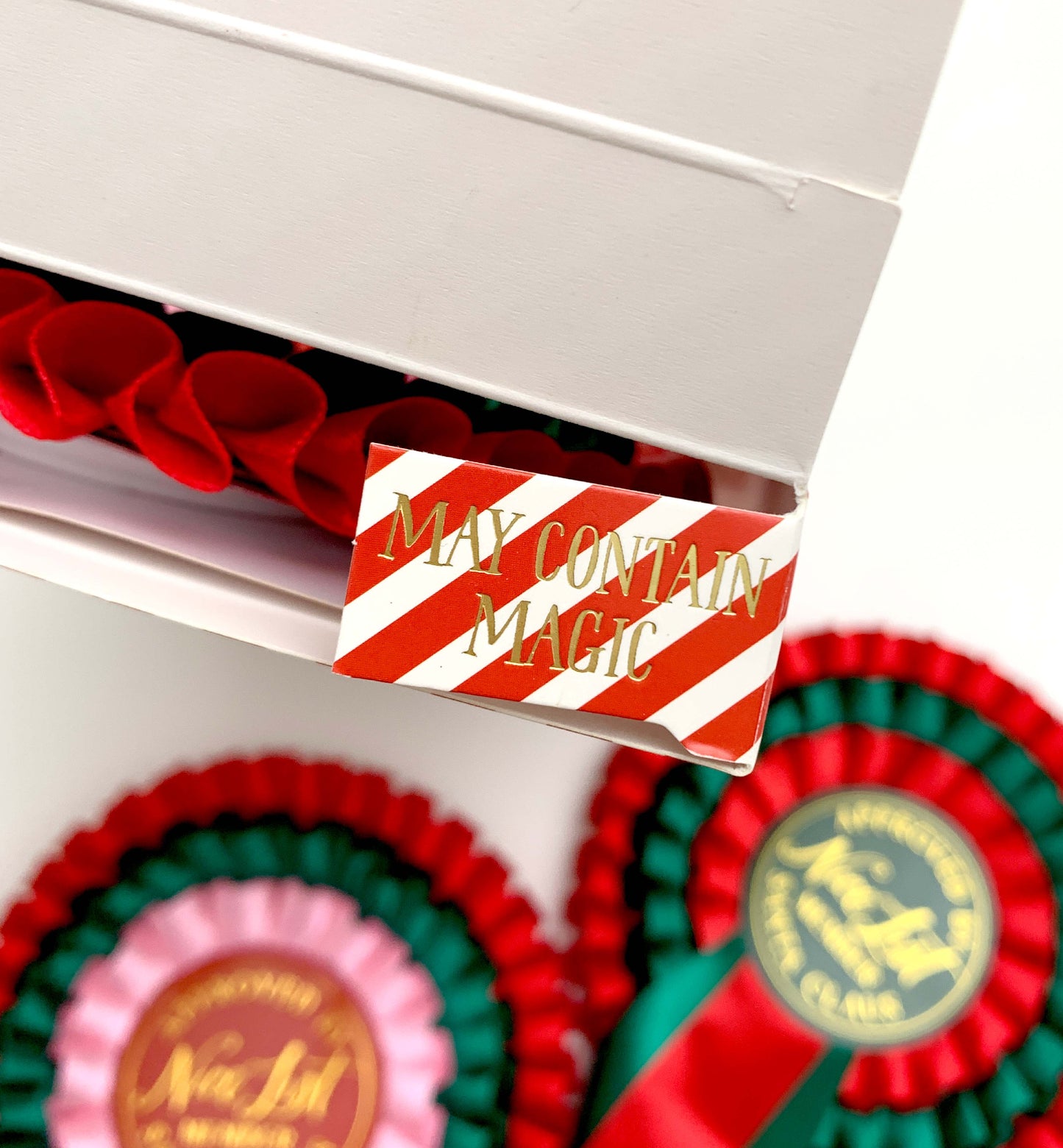 Red and white striped label with 'May Contain Magic' text on a box with decorative ribbons. Nice List Member Rosette Pink Red Green, Christmas Eve Box Gift, Present From Santa Claus, Kids Christmas Gift, Nice List Member Gift