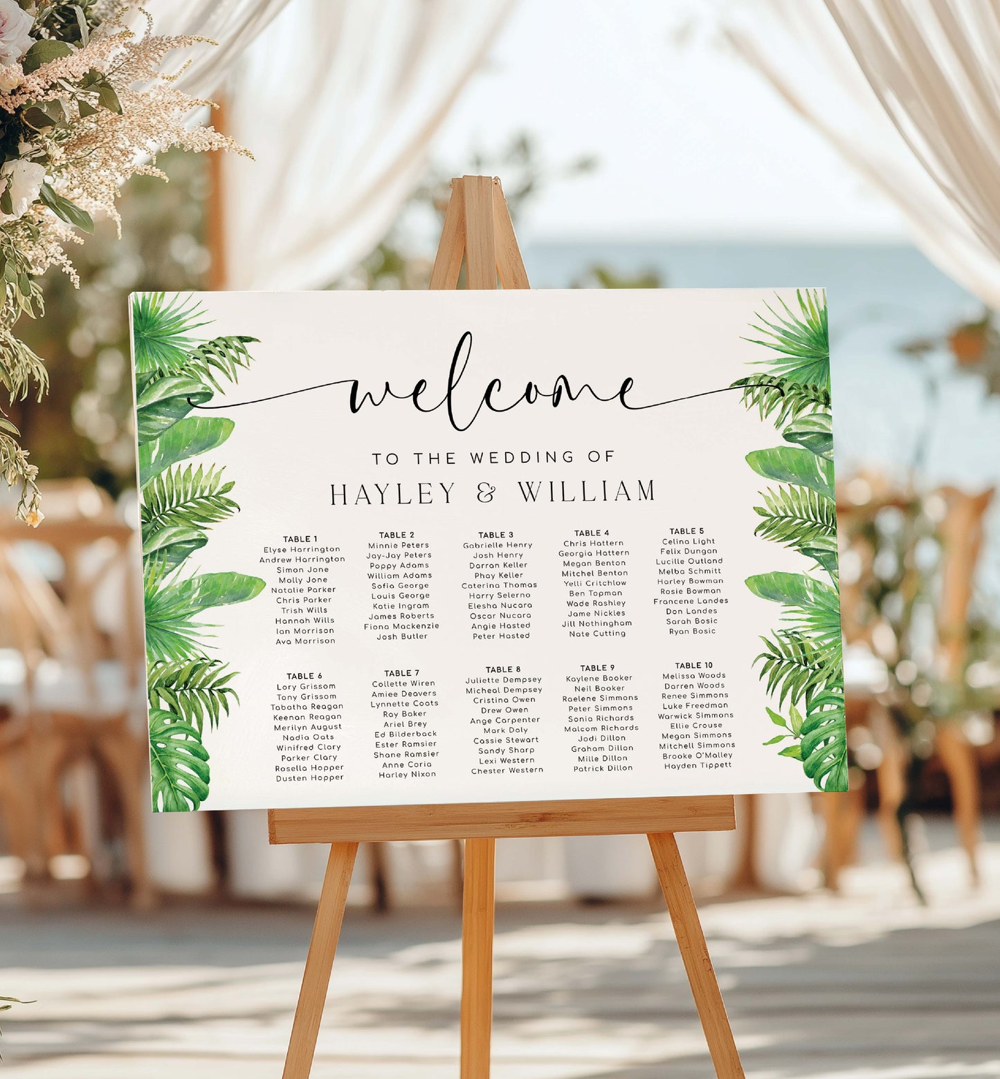 Wedding seating chart with tropical leaf design on an easel outdoors. Tropical Palm Wedding Table Plan, Printable Editable Seating Chart Template, Tropical Greenery Wedding Seating Plan Card, Nantucket Palm