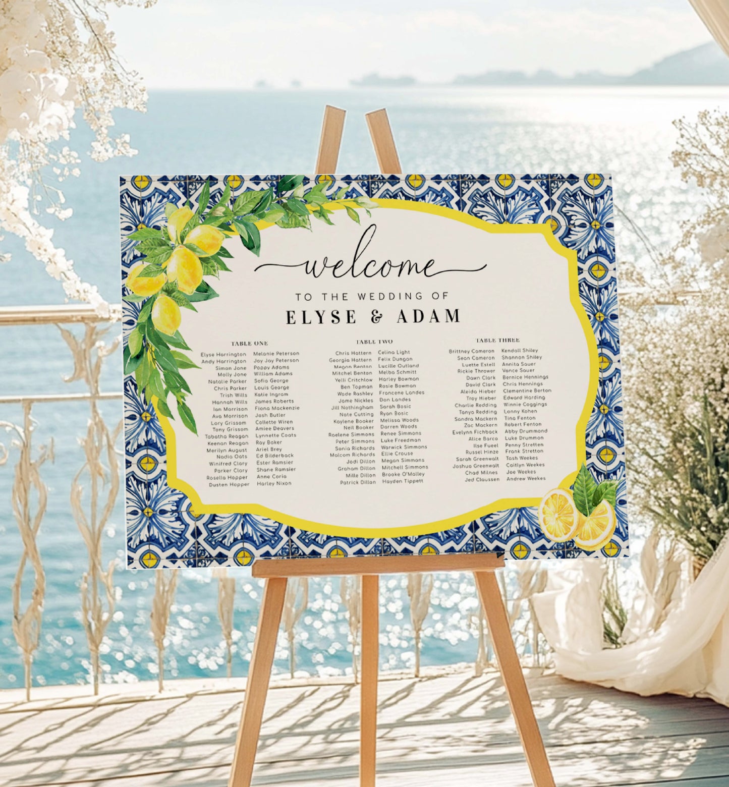 Wedding seating chart with decorative border on an easel by a scenic location. Printable Wedding 3 Banquet Table Plan, Italian Theme, Positano Blue Tile Lemon Seating Chart, Seating Plan Poster, Guest List Seating Sign