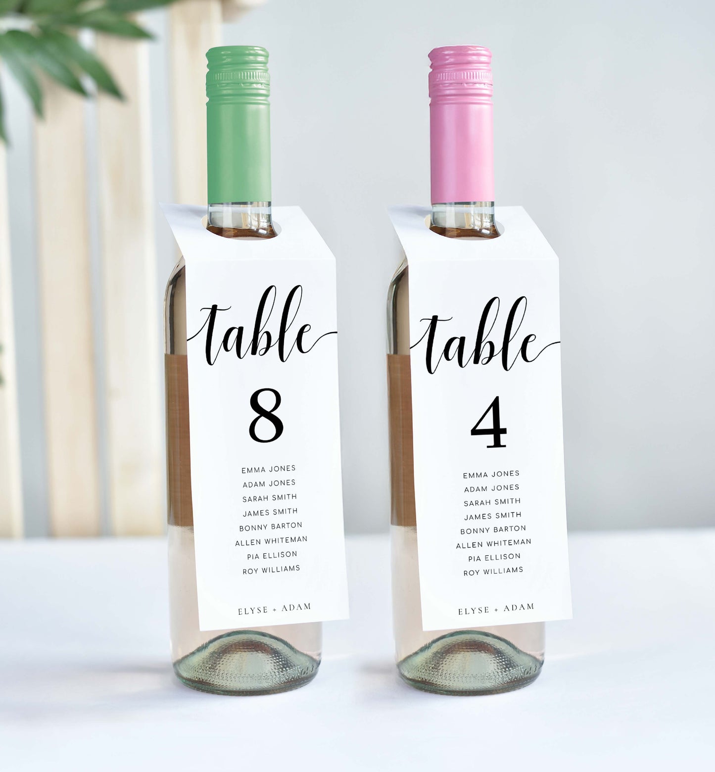 Two wine bottles with table number labels on a white background. Printable Table Number Wine Bottle Tags, Minimalist Wedding Table Numbers, Table Seating Plan Cards, Table Numbers with Guest Names, Leyton