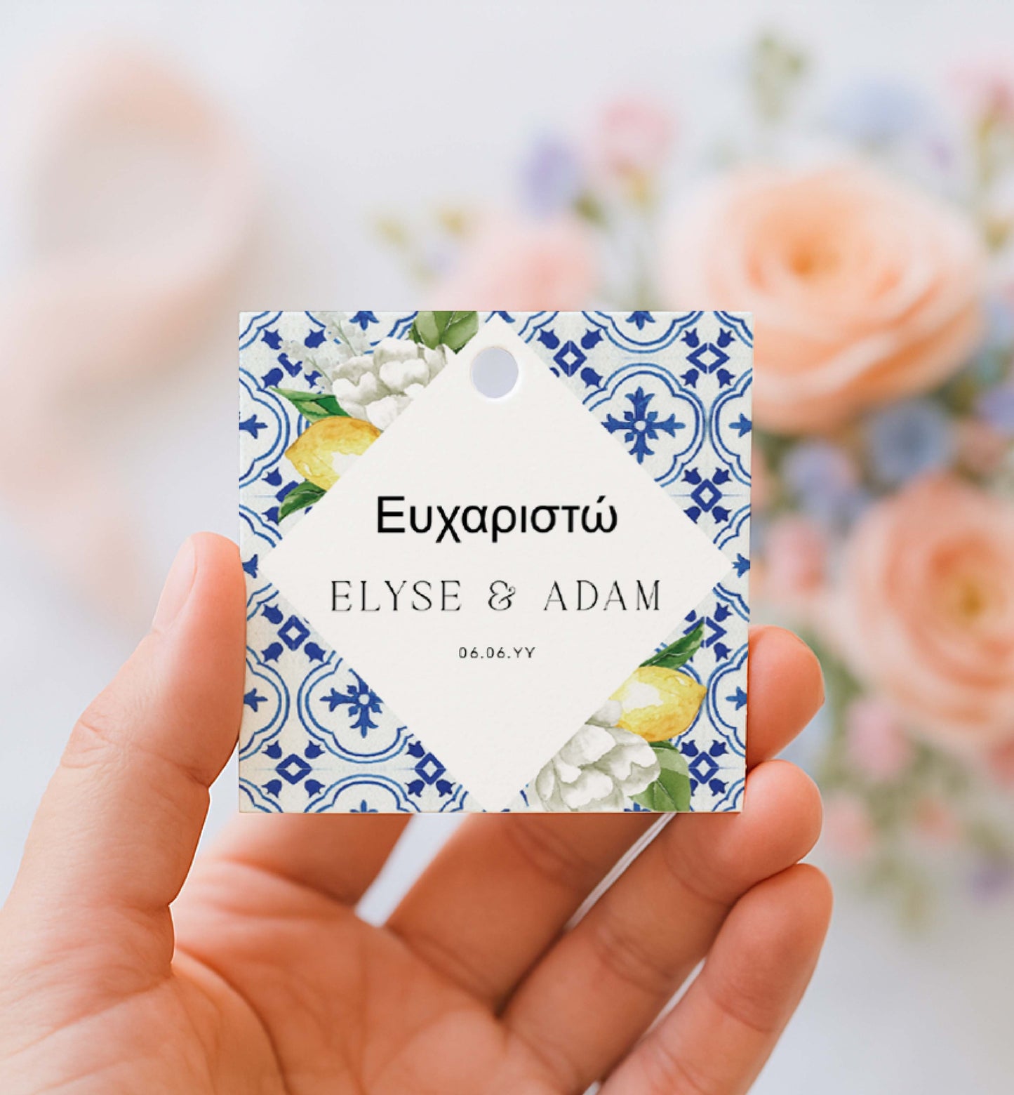 Hand holding a decorative tag with floral and lemon design, featuring names 'Elyse & Adam' and date. Printable Thank You Tag, Mediterranean Blue Tile Favor Tags, Lemons Thank You Grazie Tags, Ευχαριστώ Favor Tags, The Med