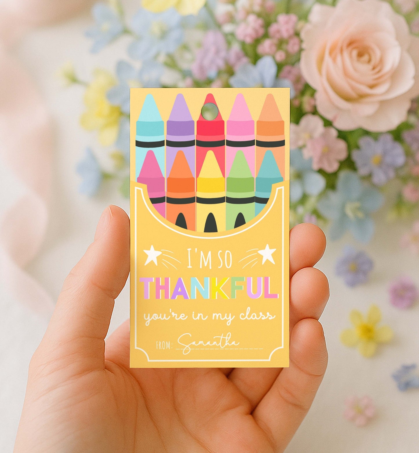 Hand holding a card with colorful crayon design and text in front of flowers. Printable Back To School Tag Template, I'm So Thankful You're In My Class Pencil Holder Tag, New School Year Classroom Gift, Crayon Gift