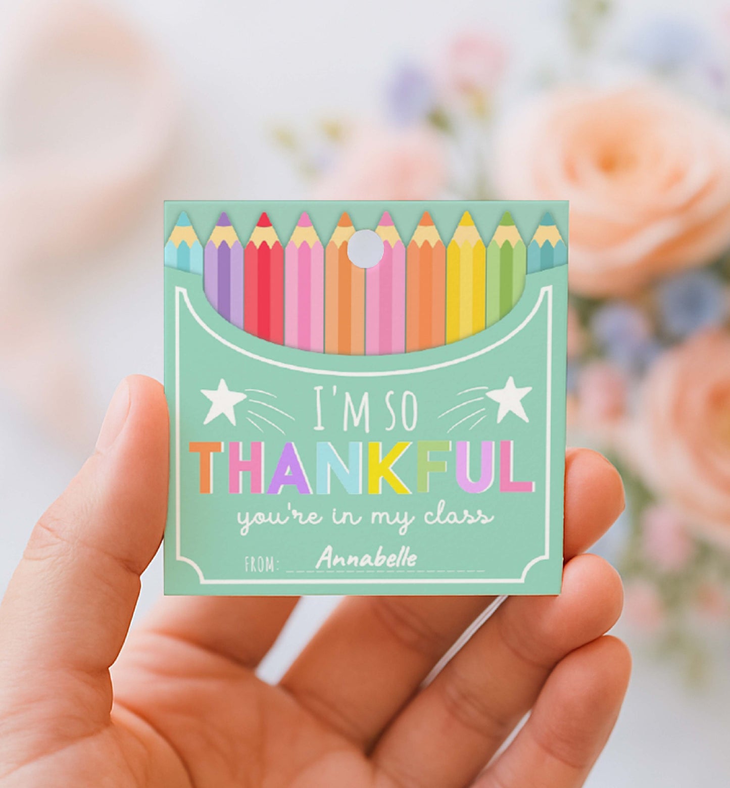 Colorful card with pencils and 'I'm so thankful you're in my class' text held by a hand with a blurred floral background.
Printable Back To School Tag Template, I'm So Thankful You're In My Class Pencil Holder Tag, New School Year Classroom Gift, Crayon Gift
