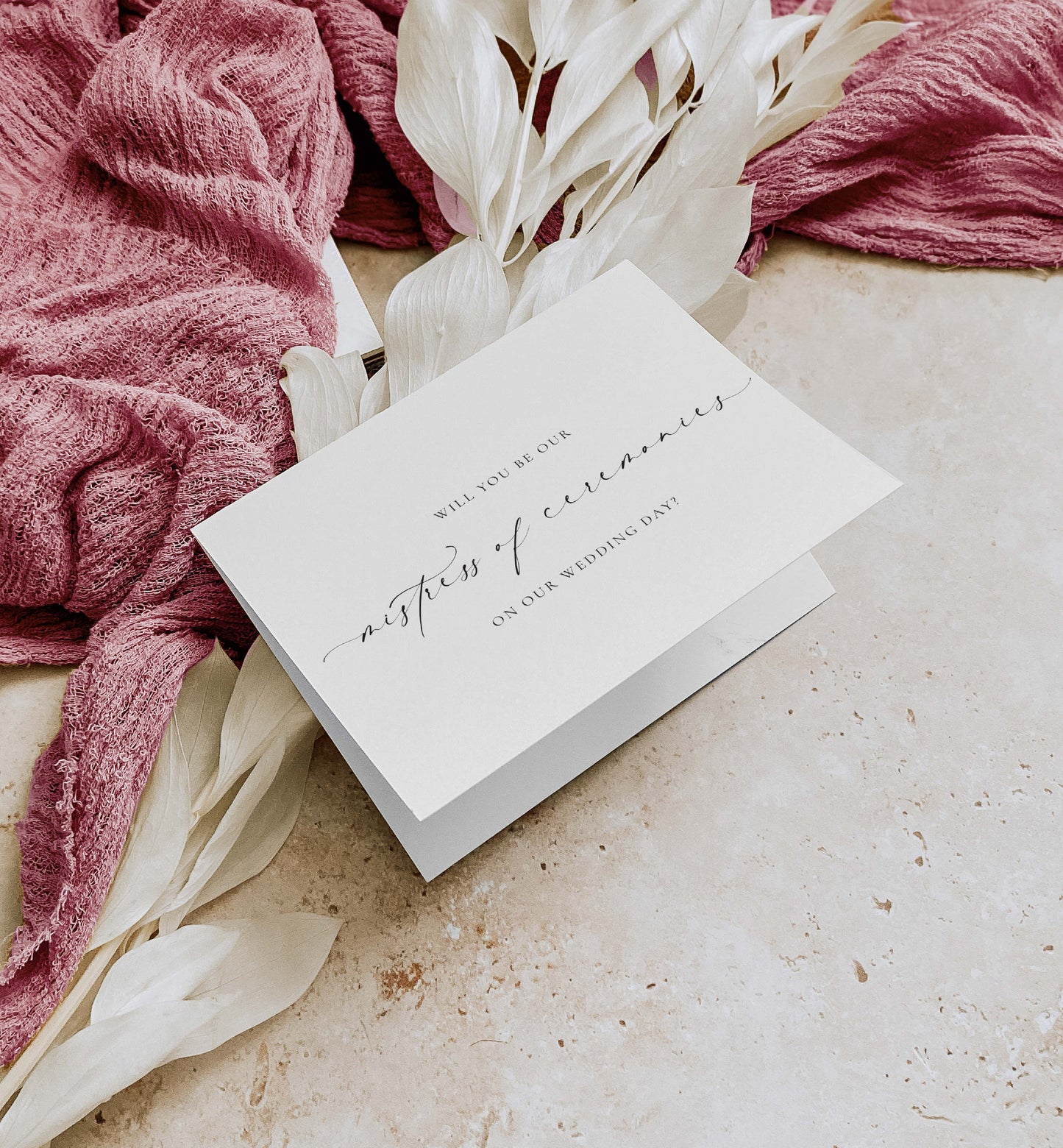 White card with wedding invitation text on a textured surface with pink fabric and white flowers. Will You Be Our Mistress of Ceremonies Card, Wedding MC Proposal Card, Minimalist Wedding Card, Wedding Proposal Card, Off White, Ellesmere