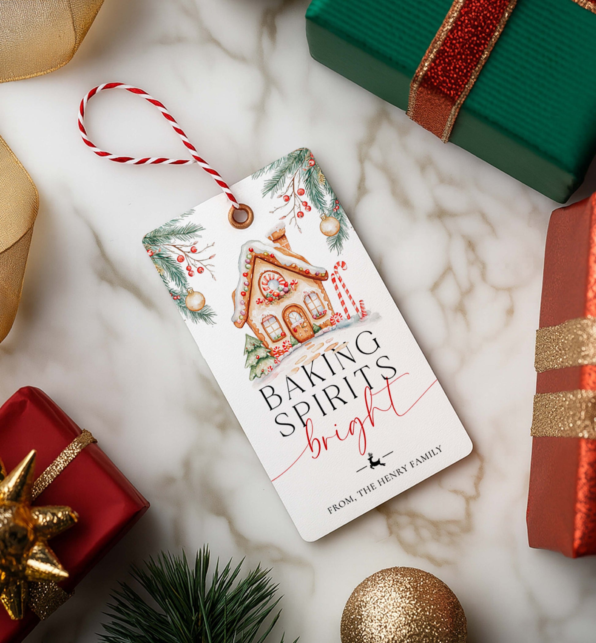 Christmas-themed gift tag with decorative text on a marble surface with wrapped gifts. Printable Baking Spirits Bright Gift Tag, Gingerbread House Gift Label, Custom Gift Label Tag, Homemade Christmas Gift Wrapping Tag
