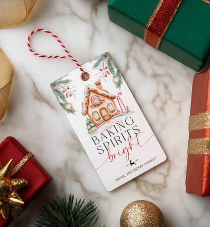 Christmas-themed gift tag with decorative text on a marble surface with wrapped gifts. Printable Baking Spirits Bright Gift Tag, Gingerbread House Gift Label, Custom Gift Label Tag, Homemade Christmas Gift Wrapping Tag