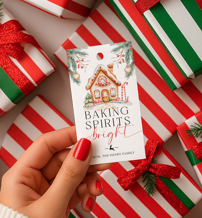 Hand holding a Christmas gift tag with 'Baking Spirits Bright' text, surrounded by wrapped gifts. Printable Baking Spirits Bright Gift Tag, Gingerbread House Gift Label, Custom Gift Label Tag, Homemade Christmas Gift Wrapping Tag