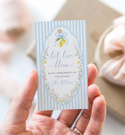 Hand holding a decorative card with floral design and text. Printable Bouquet Bar Sign, Spring Wildflower, Blue Bow Bridal Shower Bouquet Station Favor Sign, Posey