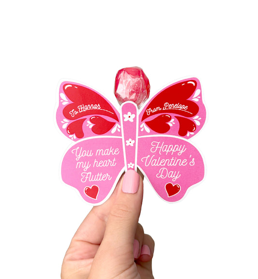 Butterfly-shaped Valentine's Day card with a lollipop, held by a hand. Butterfly Valentine's Day Lollipop Tags Template, Printable You Make My Heart Flutter Lollipop Tag, Pretty Fly Sucker Tag, Kids Valentines