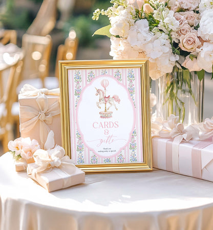Decorative table setting with a framed card, flowers, and gifts on a white tablecloth. Printable Cards and Gifts Sign, Vintage Carousel Unicorn Horse, Present Table Sign, Girl Baby Shower Sign, First Birthday Gift Table Sign