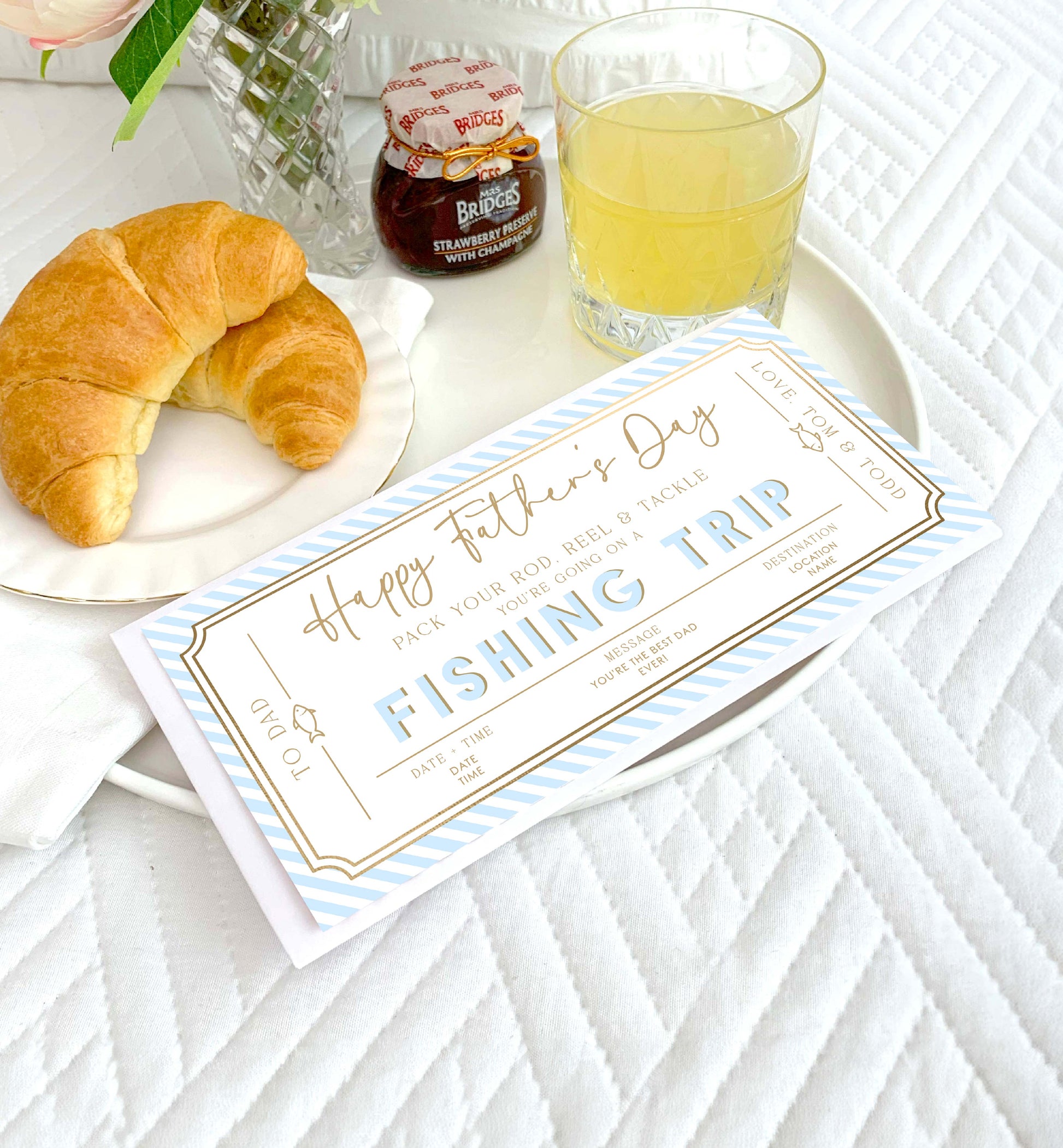 Breakfast setting with a 'Happy Father's Day Fishing Trip' card on a white tablecloth. Printable Father's Day Fishing Trip Gift Voucher, Editable Surprise Experience Card