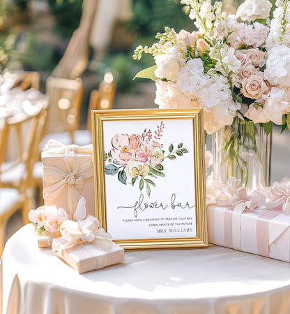 Decorative table setting with a framed sign, flowers, and gift boxes at an event. Vintage Blush Floral Flower Bar Sign, Printable Boho Bridal Shower Flower Station Sign, Bouquet Bar Sign, Flower Station Sign, Cambridge