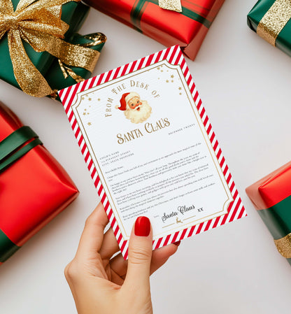 Letter from Santa Claus held by a hand with Christmas presents in the background. Printable Letter From Santa Template, Approved Nice List Member Letter From Santa Claus, Christmas Letter From Santa, Stripe Red