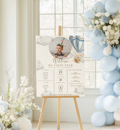 Decorative setup with a photo of a baby on a stand, balloons, and flowers in a room. Printable Baby Milestone Board, Teddy Bear Beary First Birthday, Baby's First Year Poster, 1st Birthday 12 Months Milestone Photo Banner Sign
