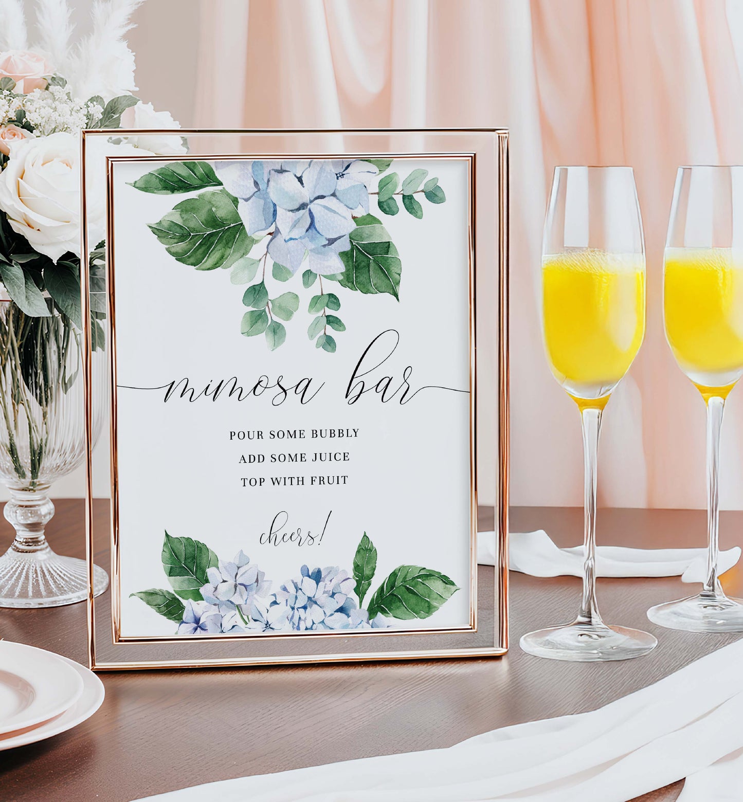 Mimosa bar sign with floral design next to champagne glasses with orange juice. Printable Mimosa Bar Sign and Juice Tags Template, Blue Hydrangea Boy Baby Shower Drinks Bar Menu Sign, Gender Neutral, Ferras Blossom