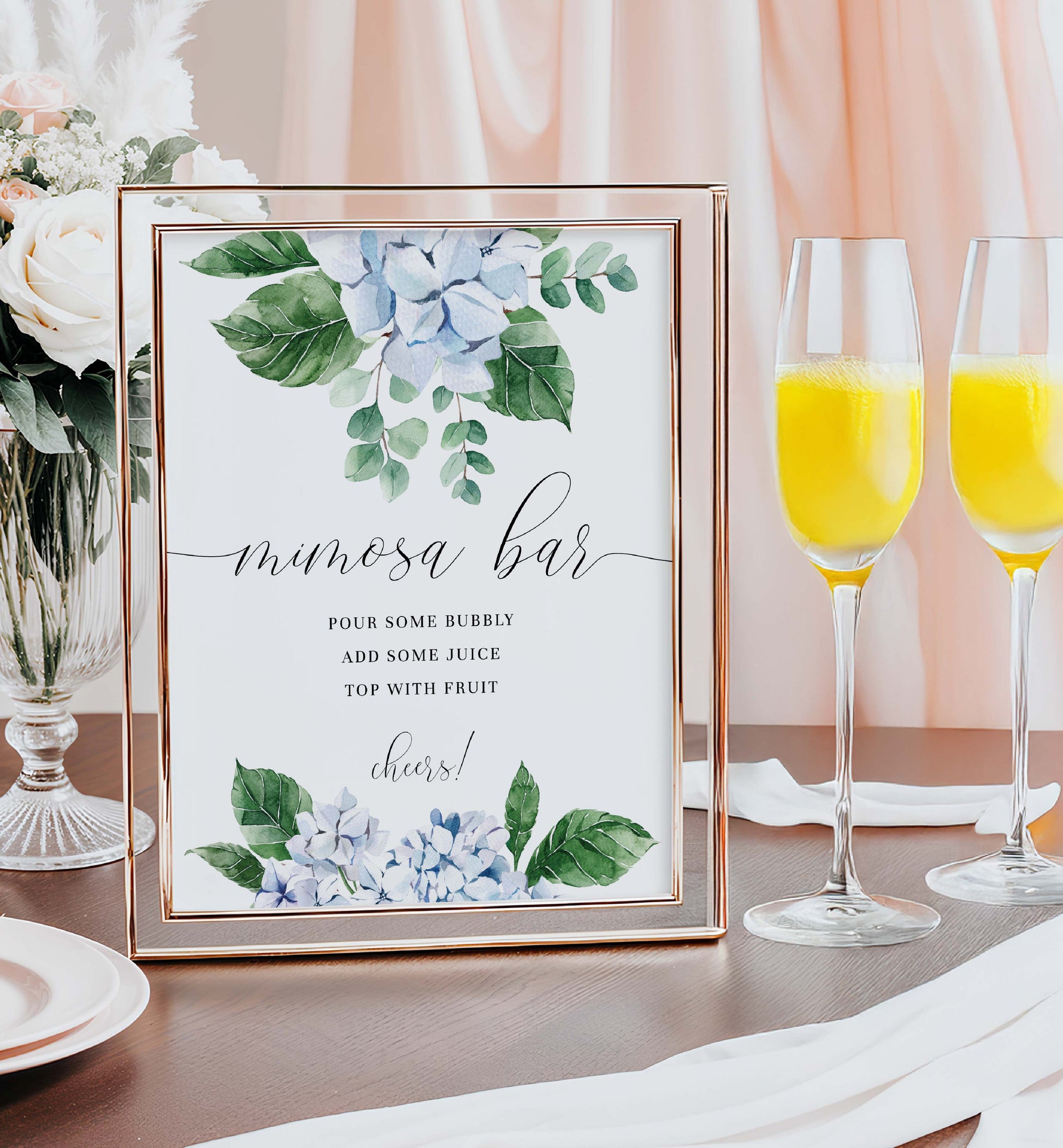 Mimosa bar sign with floral design next to champagne glasses with orange juice. Printable Mimosa Bar Sign and Juice Tags Template, Blue Hydrangea Boy Baby Shower Drinks Bar Menu Sign, Gender Neutral, Ferras Blossom