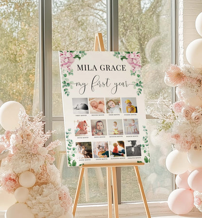 Collage of a baby's first year photos on a decorative board with floral elements, displayed on an easel in a room with balloons and decorations.
