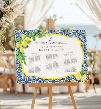 Wedding seating chart with decorative border on an easel. 

Printable Wedding 3 Banquet Table Plan, Italian Theme, Positano Blue Tile Lemon Seating Chart, Seating Plan Poster, Guest List Seating Sign