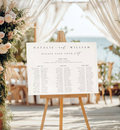 Wedding seating chart on an easel with floral decorations and outdoor setting. 

Printable Wedding Table Plan Template, Minimalist Wedding Banquet Long Tables Seating Chart Template, Wedding Seating Plan Poster, Ellesmere