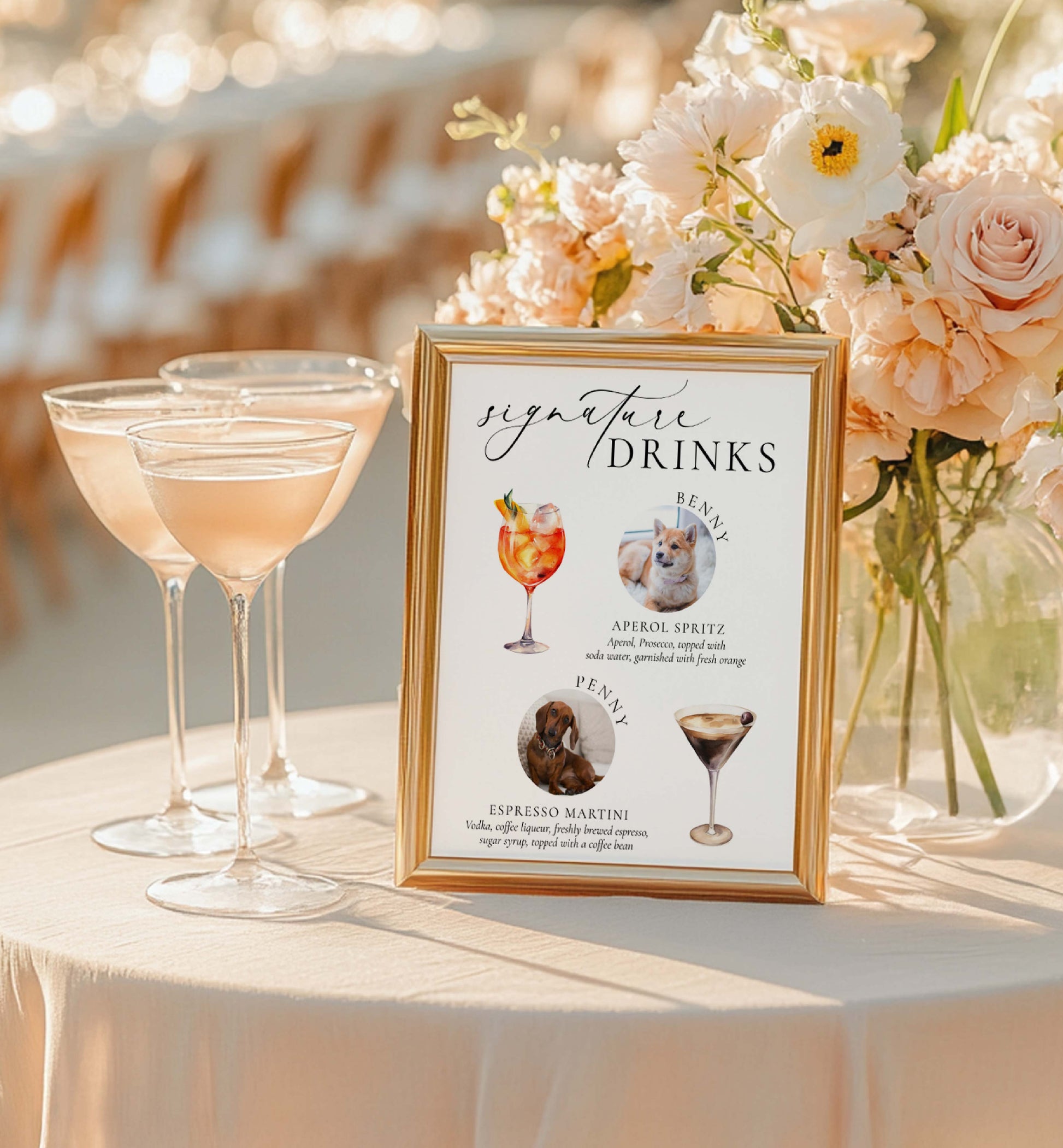 Signature drinks sign with cocktails and dogs' faces next to floral arrangement and glasses on a table.
