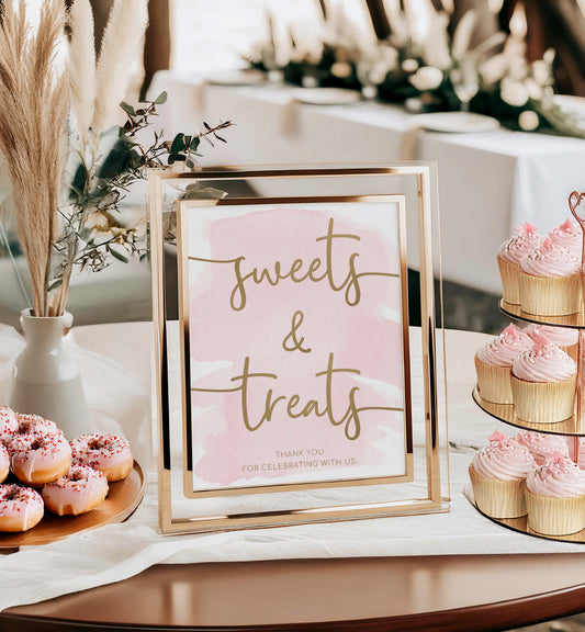 Decorative sign with 'sweets & treats' text in a gold frame, surrounded by pink donuts and cupcakes on a table. Sweets and Treats Favors Sign, Pink Watercolour Printable Favours Sign, Gold Foil, Bridal and Baby Favors Shower Sign, Wedding Favors Sign