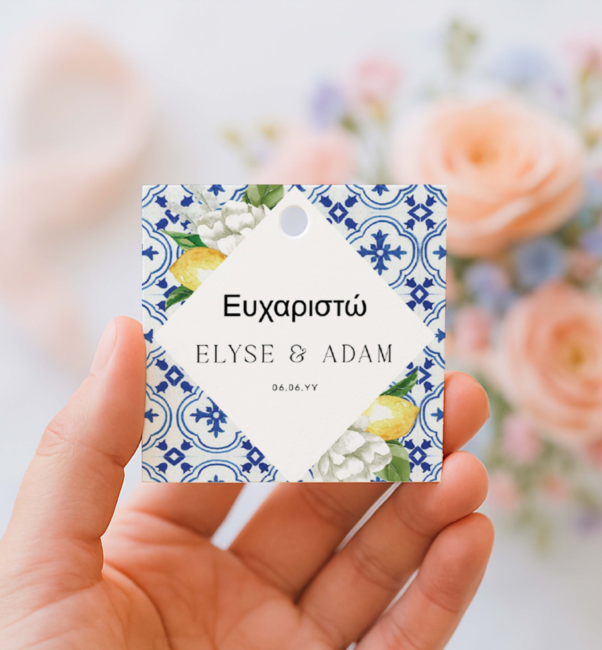 Hand holding a decorative tag with floral and lemon design, featuring names 'Elyse & Adam' and date. Printable Thank You Tag, Mediterranean Blue Tile Favor Tags, Lemons Thank You Grazie Tags, Ευχαριστώ Favor Tags, The Med