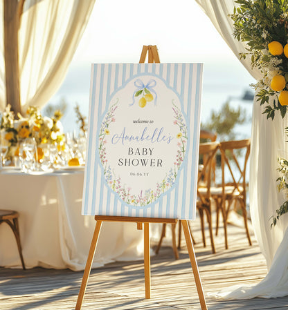 Baby shower welcome sign on an easel with floral and lemon design, set against a beachside backdrop. Printable Bridal Shower Welcome Sign, Spring Wildflower, Blue Bow Ribbon, Bachelorette Party, Hens Party, Baby Shower Welcome Sign, Baby In Bloom