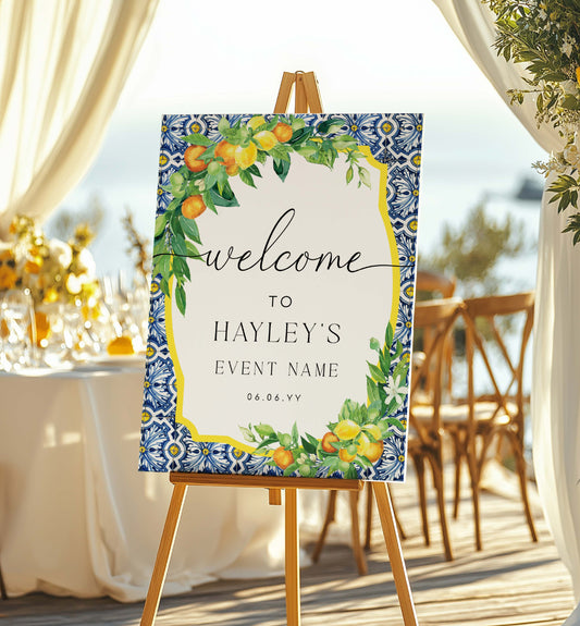Decorative welcome sign on an easel with floral and fruit design, set against a wedding reception backdrop. Printable Welcome Sign, Positano Blue Tile, Italian Oranges Lemons, Printable Wedding Sign, Bridal Shower Welcome Sign, Baby Shower Sign