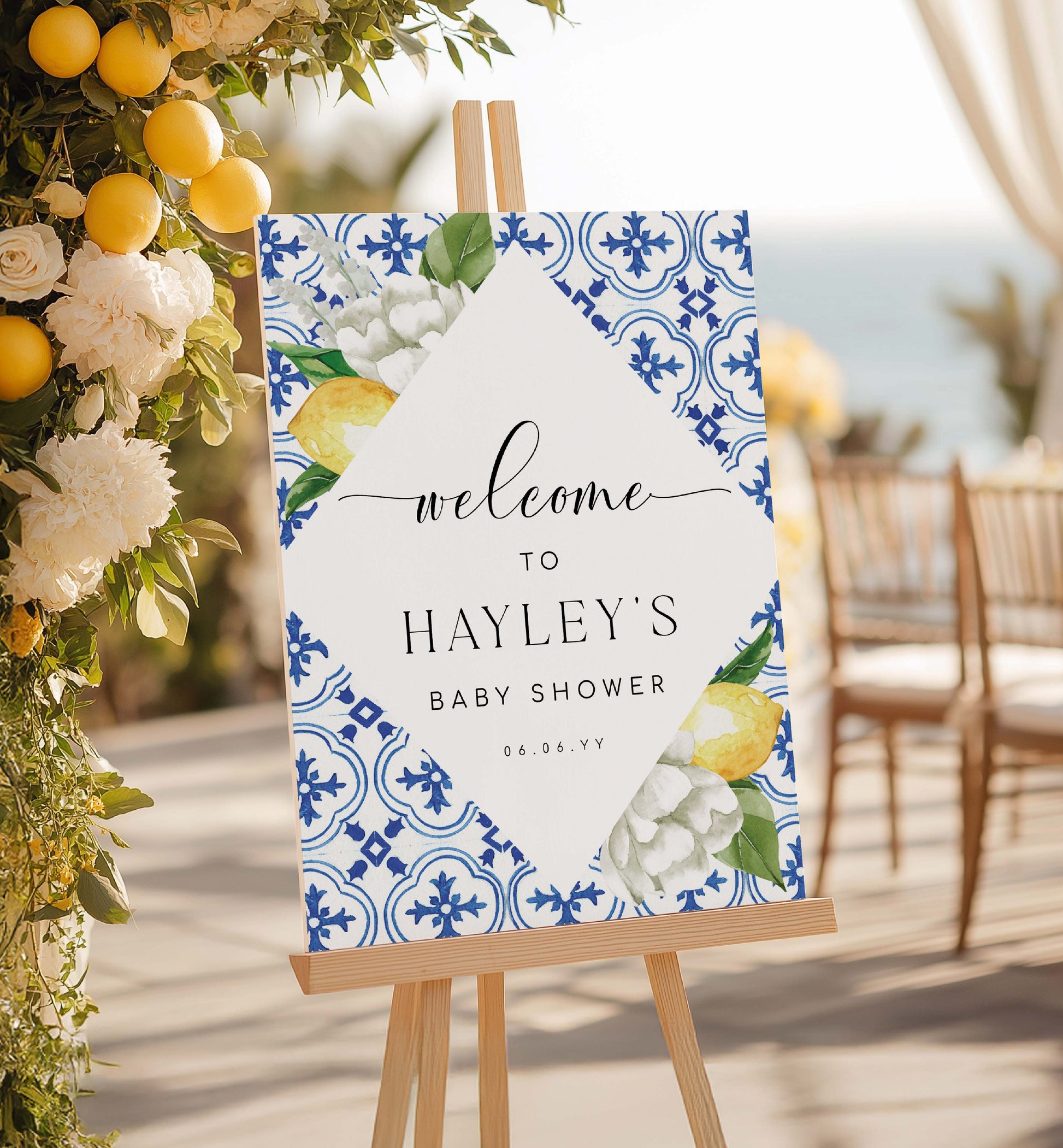 Baby shower welcome sign with floral and lemon design on an easel, surrounded by decorative flowers and lemons. Mediterranean Blue Tile Lemons Wedding Welcome Sign Template, Printable Capri Lemons Wedding Sign, Bridal Shower Welcome Sign, The Med